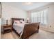 Cozy bedroom with a dark wood sleigh bed, patterned accent wall, and sheer curtains at 30989 Summer Sun Loop, Wesley Chapel, FL 33545