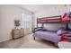 Bedroom featuring a bunk bed with purple and pink linens, neutral walls and a small dresser at 30989 Summer Sun Loop, Wesley Chapel, FL 33545