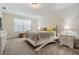 Bright bedroom featuring a white bed frame, gray and yellow bedding, and matching nightstands with lamps at 30989 Summer Sun Loop, Wesley Chapel, FL 33545