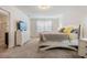 Bright bedroom featuring a white bed frame, gray and yellow bedding, and a white dresser with a TV at 30989 Summer Sun Loop, Wesley Chapel, FL 33545
