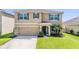 Inviting two-story home featuring a well-maintained lawn, and a two-car garage at 30989 Summer Sun Loop, Wesley Chapel, FL 33545