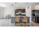 Modern kitchen featuring dark cabinets, granite countertops, stainless steel appliances, and a central island with bar seating at 30989 Summer Sun Loop, Wesley Chapel, FL 33545
