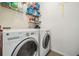 Laundry room featuring a white washer and dryer with overhead shelving at 30989 Summer Sun Loop, Wesley Chapel, FL 33545