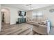 Cozy living room with light hardwood floors, a large TV, and comfortable seating at 30989 Summer Sun Loop, Wesley Chapel, FL 33545