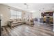Bright living room features hardwood floors, a large sofa, and an open layout with the kitchen at 30989 Summer Sun Loop, Wesley Chapel, FL 33545
