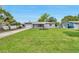 Well-maintained front yard with lush green grass, a small garden, and a long driveway at 3100 70Th N St, St Petersburg, FL 33710