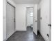 Hallway leading to bathroom shows neutral paint, grey tile floor, and access to an exterior door at 3100 70Th N St, St Petersburg, FL 33710
