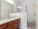 Well-lit bathroom showcasing vanity with granite countertop and tiled walk-in shower with glass partition at 311 W Ida St, Tampa, FL 33603