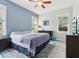 Comfortable bedroom with blue accent wall, a ceiling fan, and natural lighting through the windows at 311 W Ida St, Tampa, FL 33603