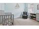 Cozy Bedroom with a rocking chair, crib, and soft blue walls, providing a comforting space at 311 W Ida St, Tampa, FL 33603