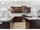 Beautiful kitchen with dark wood cabinets, stainless steel appliances, and light granite countertops at 311 W Ida St, Tampa, FL 33603