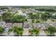 Aerial view of neighborhood with homes, trees, and lake in the background on a sunny day at 31331 Anniston Dr, Wesley Chapel, FL 33543