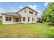 An exterior view of the home reveals a spacious backyard with a covered patio at 31331 Anniston Dr, Wesley Chapel, FL 33543