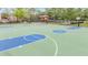 Community basketball court with bright blue and green colors and playground in the background at 31331 Anniston Dr, Wesley Chapel, FL 33543