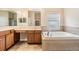 Bathroom boasts a double sink vanity, soaker tub, and window, and neutral tile flooring at 31331 Anniston Dr, Wesley Chapel, FL 33543