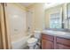 Bathroom featuring tub with shower and single sink vanity with dark wood cabinets at 31331 Anniston Dr, Wesley Chapel, FL 33543