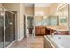 Primary bathroom features a glass shower, garden tub, double sink vanity, and neutral tile at 31331 Anniston Dr, Wesley Chapel, FL 33543