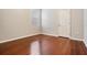 This empty bedroom has gleaming wood floors, light gray walls and a window at 31331 Anniston Dr, Wesley Chapel, FL 33543