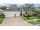 Beautiful two-story home with three-car garage, stone accents, a well-manicured lawn, and mature trees at 31331 Anniston Dr, Wesley Chapel, FL 33543