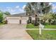 Charming two-story home with a well-maintained lawn, mature tree, and a three-car garage at 31331 Anniston Dr, Wesley Chapel, FL 33543
