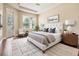 Stylishly furnished main bedroom offers a decorative ceiling, wood flooring and a door to the exterior at 31331 Anniston Dr, Wesley Chapel, FL 33543