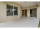 The covered patio features two sliding glass doors, a window, and neutral paint at 31331 Anniston Dr, Wesley Chapel, FL 33543