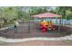 Community playground with a swing set, slide, merry-go-round, and monkey bars, all set in a wood chip base at 31331 Anniston Dr, Wesley Chapel, FL 33543