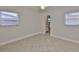 Bright bedroom with tiled flooring, two windows with blinds, and an open door to the bathroom at 3209 W Tyson Ave, Tampa, FL 33611