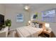 Sunlit bedroom with neutral tones and decor, complemented by tile floors and natural light from two windows at 3209 W Tyson Ave, Tampa, FL 33611