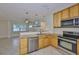 Bright kitchen features granite countertops, stainless steel appliances, and open layout to living room at 3209 W Tyson Ave, Tampa, FL 33611