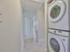 Modern stackable washer and dryer, adjacent to a hallway with neutral walls and tiled floor at 3209 W Tyson Ave, Tampa, FL 33611