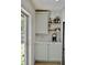 Stylish bar area featuring white cabinets, countertop, and open shelving for glassware at 34 Harbor Oaks Cir, Safety Harbor, FL 34695