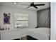 A modern bedroom with a ceiling fan, decorative gray accent wall, and window at 34 Harbor Oaks Cir, Safety Harbor, FL 34695