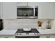 Modern kitchen with stainless steel microwave, white backsplash, and range at 34 Harbor Oaks Cir, Safety Harbor, FL 34695