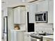 Bright kitchen featuring stainless steel appliances, white cabinets, and stylish countertops at 34 Harbor Oaks Cir, Safety Harbor, FL 34695