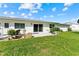 Green backyard with patio seating and sliding glass doors providing a relaxing outdoor space at 3410 Stonehaven E Ct # A, Palm Harbor, FL 34684