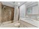 Bathroom with tub-shower combo featuring a modern shower head, patterned curtain and vanity with granite countertop at 3410 Stonehaven E Ct # A, Palm Harbor, FL 34684
