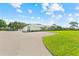 Spacious single-story home with a long driveway, a well-manicured lawn, and an attached three-car garage at 3410 Stonehaven E Ct # A, Palm Harbor, FL 34684