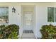 Close up of front door showing sidelight windows and manicured shrubbery at 3410 Stonehaven E Ct # A, Palm Harbor, FL 34684