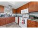 Kitchen showcasing wooden cabinets, sleek countertops and white appliances at 3410 Stonehaven E Ct # A, Palm Harbor, FL 34684