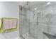 Modern shower with glass door, pebble floor, and neutral-toned tile, providing a spa-like experience at 3410 Stonehaven E Ct # A, Palm Harbor, FL 34684