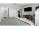 Bedroom featuring a large bed, mounted TV, and ensuite bathroom at 34248 Redwood Dawn Ln, Wesley Chapel, FL 33543