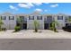 Inviting two-story townhome showcases a well-manicured lawn, attached garage, and neutral paint scheme at 34248 Redwood Dawn Ln, Wesley Chapel, FL 33543