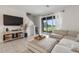 Comfortable living area with a large sectional sofa and views of the outdoors through sliding glass doors at 34248 Redwood Dawn Ln, Wesley Chapel, FL 33543