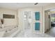 Bathroom showcasing a modern soaking tub, tiled floors, and access to a toilet room at 3936 Crooked Island Dr, Punta Gorda, FL 33950