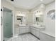 Bright bathroom featuring double sinks, ample cabinetry, a glass door shower, and tile floor at 3936 Crooked Island Dr, Punta Gorda, FL 33950