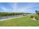 Scenic view of a property's waterfront dock with boat, lush green lawn, and serene water views at 3936 Crooked Island Dr, Punta Gorda, FL 33950