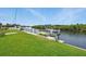 Waterfront property featuring a manicured lawn, access to a boat dock and river at 3936 Crooked Island Dr, Punta Gorda, FL 33950