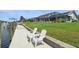 Waterfront home featuring a private boat dock and green grass, perfect for enjoying outdoor relaxation by the canal at 3936 Crooked Island Dr, Punta Gorda, FL 33950