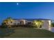 This beautiful single Gathering home has a well-manicured lawn, lush landscaping, and a moonlit sky at 3936 Crooked Island Dr, Punta Gorda, FL 33950
